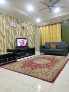 sala de estar con sofá y TV en Homestay Cikgu Zedi Hulu Langat en Hulu Langat