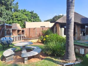 un patio trasero con mesa, sillas y mesa de billar en Residential Inn en Pretoria