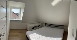 - une petite chambre avec un lit et une fenêtre dans l'établissement Centro apartamentai, à Kalvarija