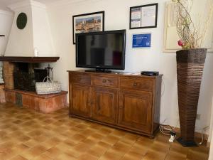 a television on a wooden cabinet in a living room at A pochi passi dal mare in Torre del Lago Puccini