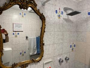 une femme prenant une photo d'une salle de bains avec miroir dans l'établissement A pochi passi dal mare, à Torre del Lago Puccini