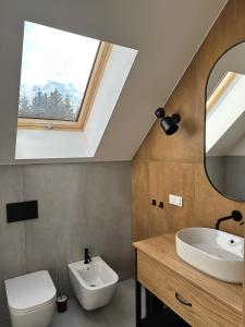 a bathroom with a sink and a toilet and a window at Młynowiec 4Rest in Stronie Śląskie