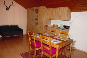 a dining room with a wooden table and chairs at Ferienwohnung Alpenblick in Anger