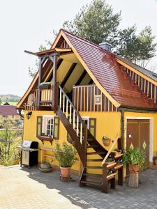a yellow house with a staircase in front of it at Loft am Malerweg in Reinhardtsdorf