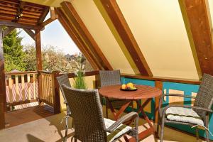 a balcony with a wooden table and chairs at Loft am Malerweg in Reinhardtsdorf