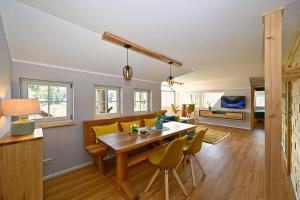 a dining room and living room with a table and chairs at Loft am Malerweg in Reinhardtsdorf
