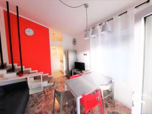 a dining room with a table and a red wall at Villa Wanda 2 in Bibione