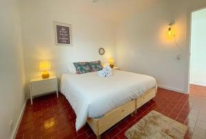 a bedroom with a bed and two lamps and a sign on the wall at Ria Beach House in Faro