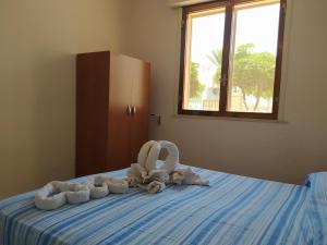 a bed with stuffed animals sitting on top of it at Villetta Mira in Torre Lapillo