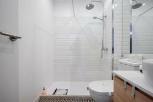 a bathroom with a shower and a toilet and a sink at Ria Beach House in Faro
