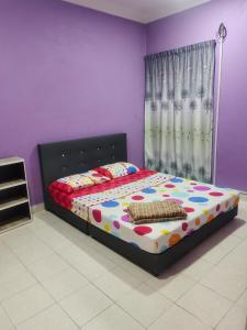 1 dormitorio con 1 cama en una habitación púrpura en Homestay Cikgu Zedi Hulu Langat en Hulu Langat