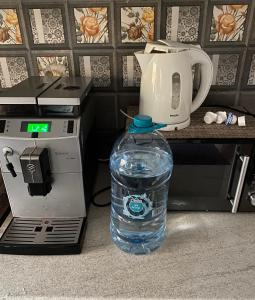 Una botella de agua sentada junto a una cafetera. en Casa Alex, en Constanţa
