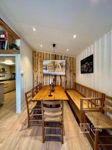 uma sala de jantar com uma mesa de madeira e cadeiras em Summer Cabin Nesodden sauna, ice bath tub, outdoor bar, gap hut em Brevik