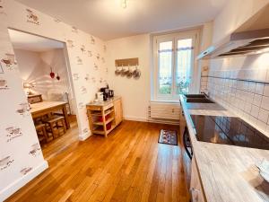 a kitchen with wooden floors and a large window at L'Ecureuil in Gérardmer +18 photos