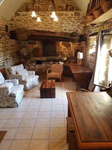 ein Wohnzimmer mit einem Tisch und einer Ziegelwand in der Unterkunft Le Four de La Jugie in Le Lonzac