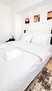 a bedroom with two beds with white sheets at Brancoveanu Apartament's in Bucharest