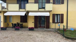 a yellow house with a patio with a table and chairs at Paola House in Lonato del Garda