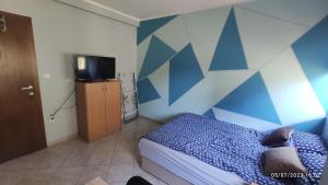 a bedroom with a blue and white wall at Apartmani MiNa in Neum