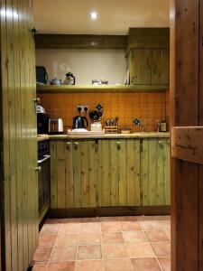 a kitchen with green wooden cabinets and a tiled floor at Cnoc Suain in Galway
