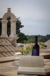 a table with a bottle of wine and a book at Grand Amore Apartment in Dubrovnik
