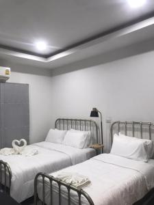 duas camas sentadas uma ao lado da outra num quarto em ONE DD HOMES em Udon Thani