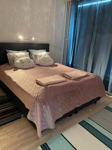 a bed with a pink blanket and pillows on it at Sweet dreams Porvoo in Porvoo