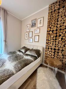 a bedroom with a bed and a wall of logs at Silesia Apartments Ustron H125 in Ustroń