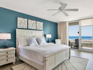 a bedroom with a large bed with a blue wall at Caribe The Resort #C813 in Orange Beach