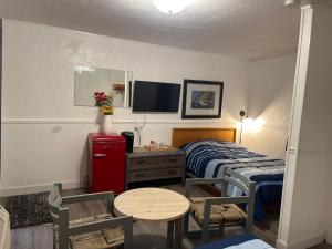 1 dormitorio con cama, mesa y TV en Cedar Vista Motel, en Tobermory