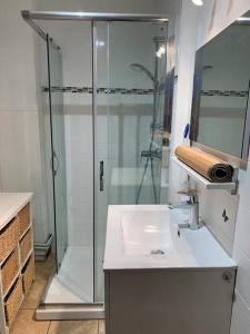 uma casa de banho com uma cabina de duche em vidro e um lavatório. em Maison de campagne em Champvans