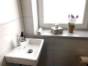 a white sink in a bathroom with a window at An der Stadtmauer Bürgel in Bürgel