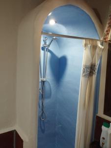 a shower with a shower curtain in a bathroom at Posada del Moral in Benaoján