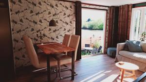 sala de estar con mesa y sofá en Het witte chalet aan het water van monumentaal fort en Ooltgensplaat