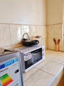 a kitchen with a stove and a microwave at Amaryllis homes , within city centre,near River Nile in Jinja