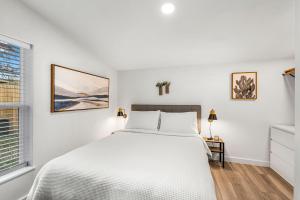 a white bedroom with a bed and a window at NEW! The Yellow Door- Downtown Wimberley w/ River Access in Wimberley
