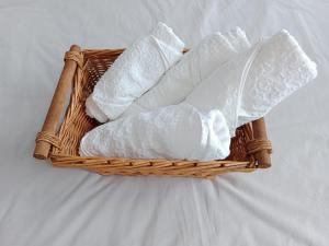 a basket filled with white towels on a bed at J&Z apartmán in Olomouc