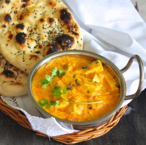 a bowl of soup and a plate of bread at Hotel bhavini in Katra