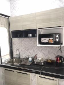 a kitchen with a sink and a microwave at ONE DD HOMES in Udon Thani