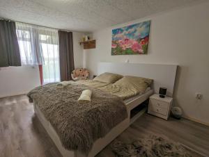 1 dormitorio con 1 cama grande con manta marrón en Sweety-Apartman en Mátészalka