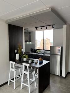 a kitchen with a table and a stainless steel refrigerator at Andean Homes in La Paz