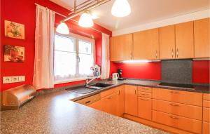 a kitchen with red walls and a sink and a window at Beautiful Apartment In Feldkirch With Wifi And 2 Bedrooms in Feldkirch