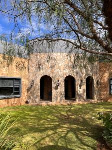 an old brick building with arches on a yard at Swan Lake Suites in Benoni