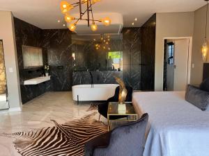 Swan Lake Suites في بينوني: حمام به سرير وحوض استحمام