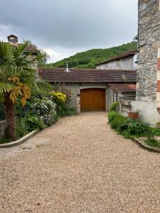 a house with a garage and a gravel driveway at Maison mitoyenne dans quartier calme in Saleich