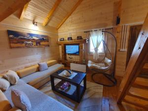 a living room with a couch and a chair in a cabin at Cabin House Dubovik in Cetinje