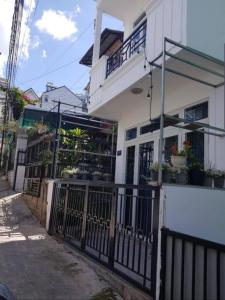 a white house with a gate and plants on it at Home 1/31 Nhà Chung Đà Lạt in Da Lat