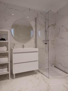 uma casa de banho branca com um lavatório e um chuveiro em Flor da Laranjeira em Elvas