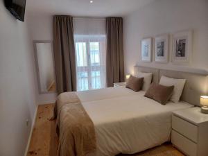 a bedroom with a large bed and a window at Flor da Laranjeira in Elvas