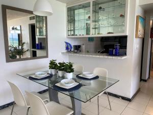 a dining room with a glass table and white chairs at Marbella del Caribe Isla Verde Beachfront in San Juan