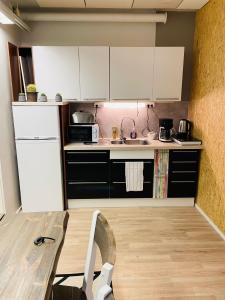 a kitchen with white cabinets and a wooden table at Sweet dreams Porvoo in Porvoo